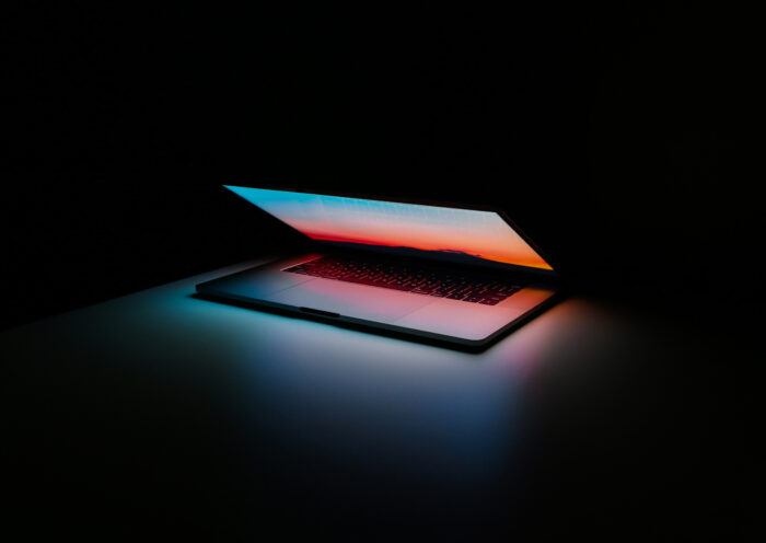 Half closed Macbook in dark room